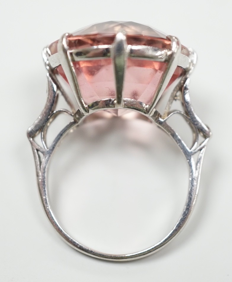 A white metal and circular cut pink tourmaline set dress ring, with three stone graduated diamond set shoulders, size I/J, gross weight 6.6 grams